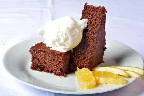 a piece of chocolate cake with ice cream and orange slices at Triniti Airport Hotel in Dar es Salaam