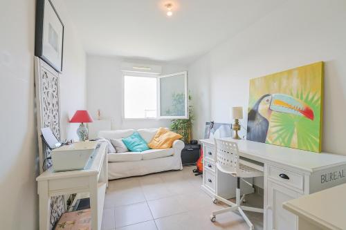 un salon avec un bureau et un canapé dans l'établissement Air-conditioned south-facing apartment, à Hyères