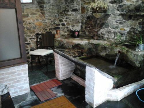 a stone kitchen with a sink in a room at Casa Rural O Carreiro in Cedeira