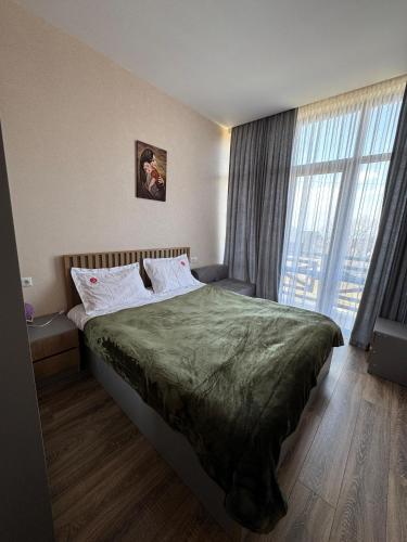 a bedroom with a bed and a large window at Eco Cottage BaBi in Bakuriani