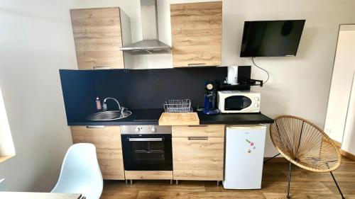 une petite cuisine avec un évier et un micro-ondes dans l'établissement Les pieds dans l'eau, à Veules-les-Roses