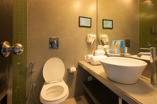 a bathroom with a toilet and a sink at Whispering Palms Beach Resort in Candolim