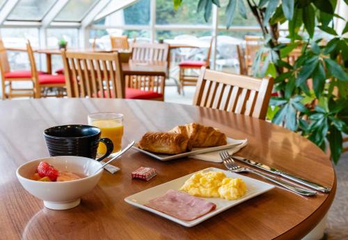 una mesa con un plato de comida y un bol de fruta en B&B HOTEL Grenoble Université 2, en Gières