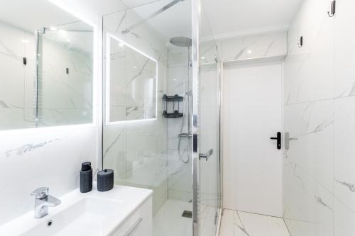 a white bathroom with a shower and a sink at Metz Appartement luxueux, design, confort premium, 80 m2, proche gare SNCF in Metz