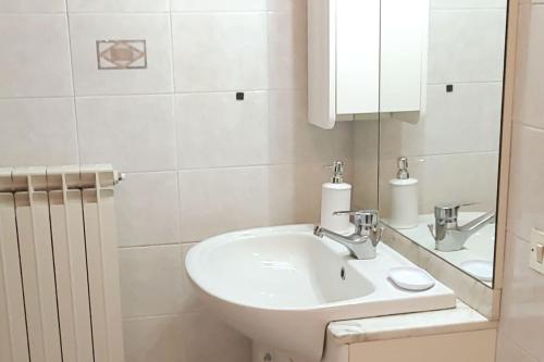 a white bathroom with a sink and a mirror at Casa Anna Cerasuolo - intera casa indipendente in borgo in Cerasuolo