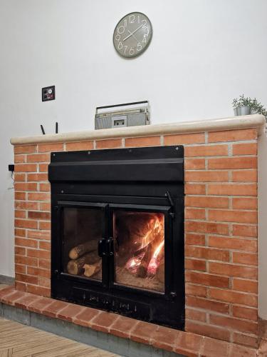a brick fireplace with a clock on the wall at Casa Anna Cerasuolo - intera casa indipendente in borgo in Cerasuolo