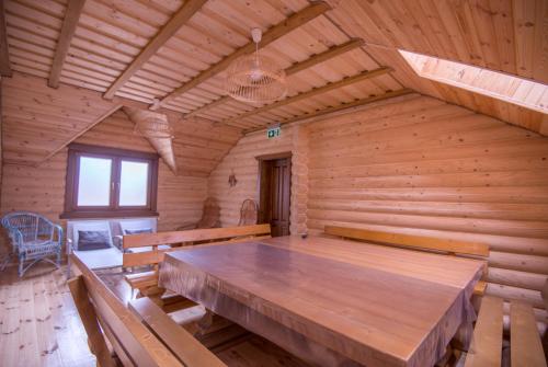 a log cabin with a large wooden table in it at Drei Bären Hotel & Apartments in Aichach