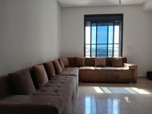 a large couch in a living room with a large window at Tanger Beach coralia in Tangier