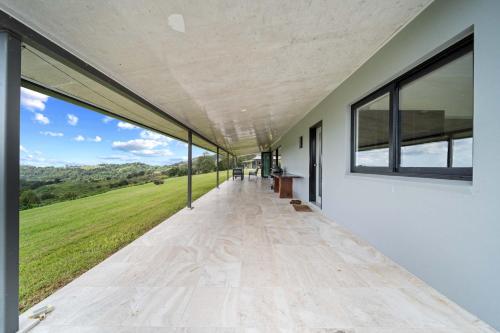 an empty hallway with windows and a view of a field at Panorama Farm - Sunshine Coast Hinterland in Bald Knob