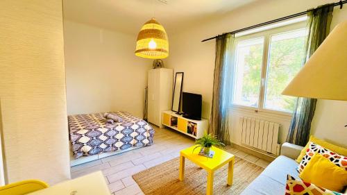 een woonkamer met een bed en een raam bij Au son des Cigales in Cassis