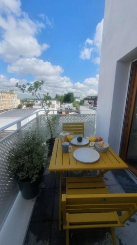 d'une table en bois sur un balcon avec vue. dans l'établissement Appartement neuf lumineux 3 chambres proche Jeux Olympiques Aubervilliers Paris, à Aubervilliers