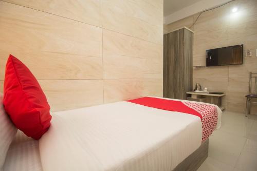 a bedroom with a bed with a red pillow at Super Capital O Priyanshu in Siliguri