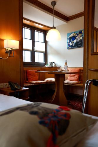 a bedroom with a table and a bench in a room at Hotel - Restaurant Le Cerf & Spa in Marlenheim