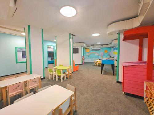 a classroom with tables and chairs and a play area at Hotel Lake House Kinneret in Tiberias