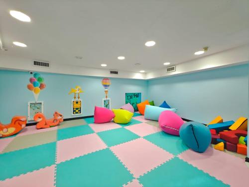 a play room with colorful chairs and a checkerboard floor at Hotel Lake House Kinneret in Tiberias