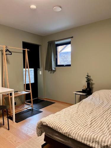 a bedroom with a bed and a desk and a window at Modern 1-room apartment - right by the Arctic Cathedral and Fjellheisen in Tromsø