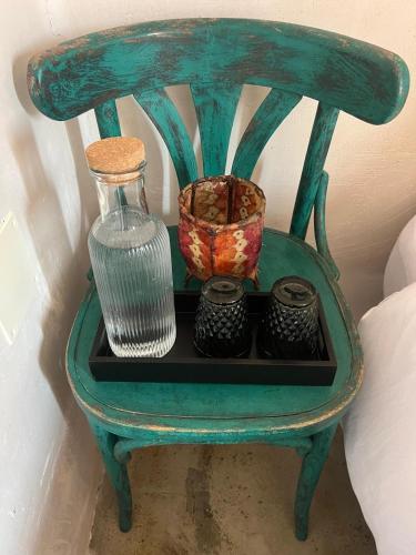 a green chair with a vase and other items on it at B&B Masia Katmandú in Cretas