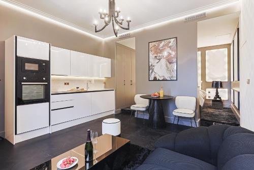 a kitchen and living room with a couch and a table at Divine Couture - Suite Cambon in Carrières-sur-Seine