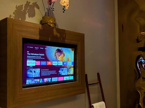 a flat screen tv sitting on a wall at The W Avenue in Bandung