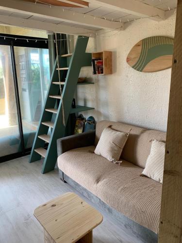 un salon avec un canapé et un escalier dans l'établissement Appartement 300m de la plage, à Seignosse