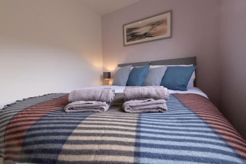 a bedroom with a bed with towels on it at Botaira, Shetland Islands in Easter Quarff