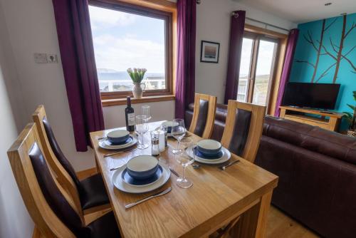 a dining room with a table and a couch at Botaira, Shetland Islands in Easter Quarff