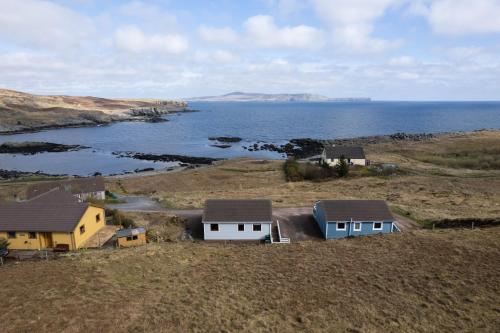 a group of houses on a hill near the ocean at Botaira, Shetland Islands in Easter Quarff