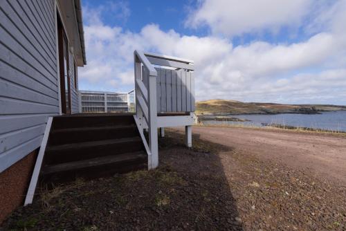 a white staircase on the side of a house at Botaira, Shetland Islands in Easter Quarff