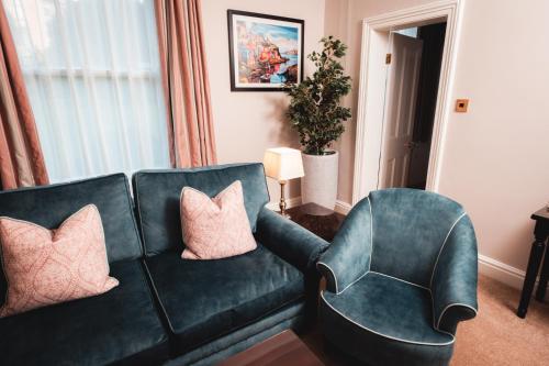 a living room with a green couch and two chairs at Old Swan Hotel in Harrogate