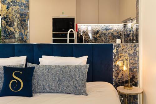a bedroom with a bed with a blue headboard at Safira Suites 302 in Funchal