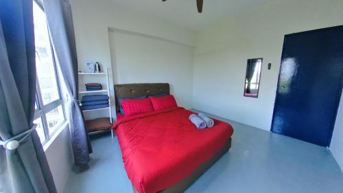 - une chambre avec un lit rouge et une couverture rouge dans l'établissement Beachfront 2-5pax, Free parking , swimming pool, à Port Dickson