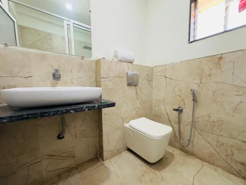 a bathroom with a sink and a toilet at Nilkanth Resort - Best Resort in Anand in Anand
