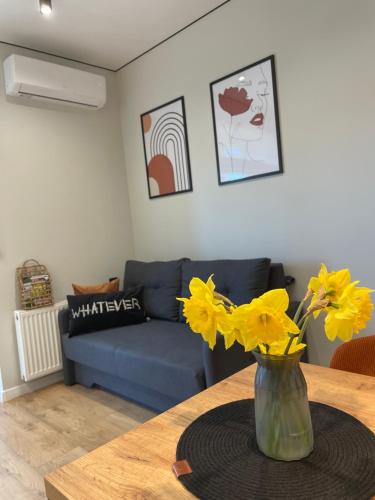 a vase with yellow flowers on a table in a living room at Нова однокімнатна квартира in Umanʼ