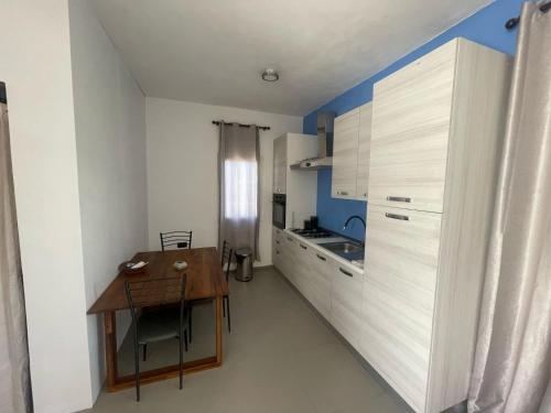 a small kitchen with a wooden table and a dining room at Iguana Apartments in Osbourn