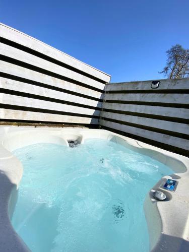 a hot tub with blue water in front of a building at Otter 2 HuntersMoon- Warminster-Wiltshire-Bristol in Warminster