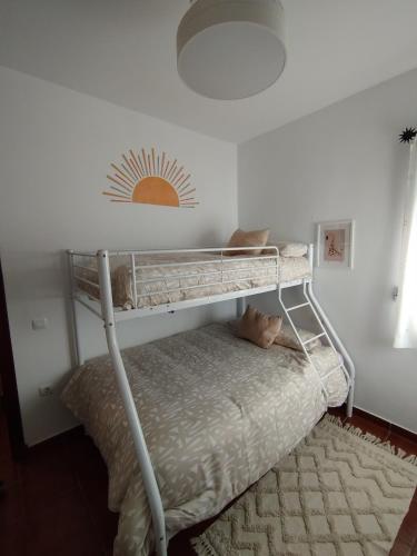 a bunk bed in a bedroom with a white wall at Brisa&Mar, con Posibilidad de Parking in Chipiona