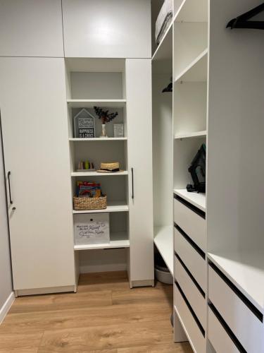 a walk in closet with white cabinets and wooden floors at Нова однокімнатна квартира in Umanʼ