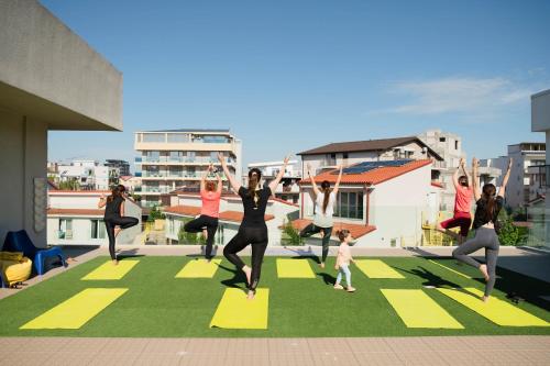 a group of people doing yoga on a rooftop at Nayino Resort Hotel in Mamaia Nord