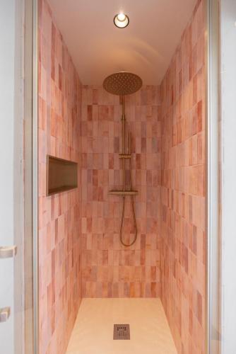 une douche avec du carrelage rose sur le mur dans l'établissement Small townhouse Roucas, à Marseille