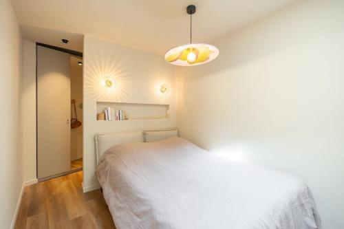 une chambre avec un lit blanc et une lampe dans l'établissement Small townhouse Roucas, à Marseille