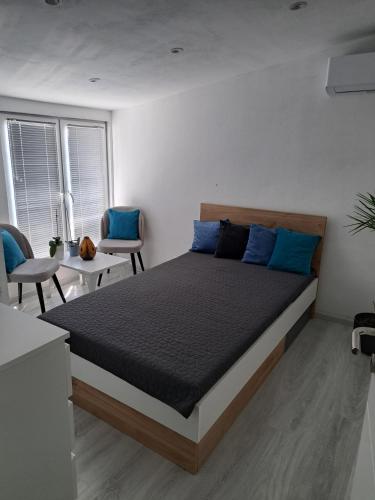a bedroom with a large bed with blue pillows at Happy Vecation in Tuzla