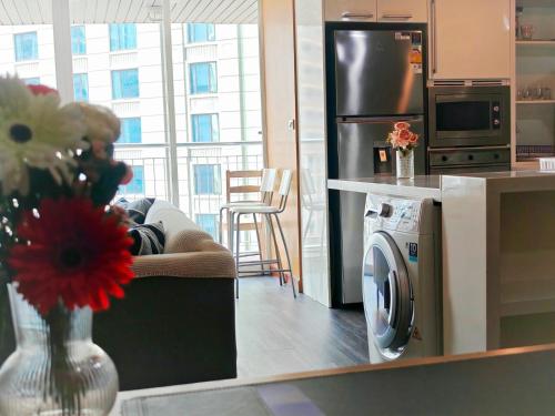 a kitchen with a refrigerator and a vase of flowers at City comfort appartment, Skytain Step 600 m, Erawan shrine in Bang Kapi