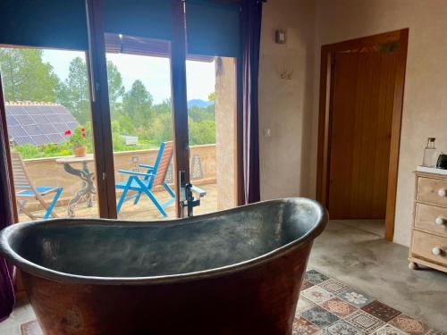 a bath tub in a bathroom with a view of a patio at B&B Masia Katmandú in Cretas