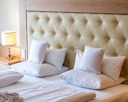 a bed with two pillows on top of it at Hotel Maximilian in Bad Griesbach
