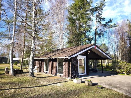 a small brick building in the middle of a park at Rozes Oga, Tūrisma mītnes namiņš in Ieriķi