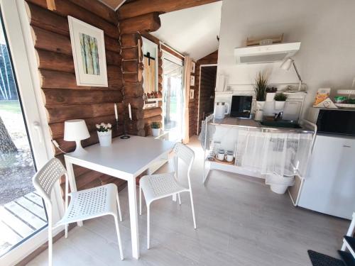 a kitchen and dining room with a table and chairs at Rozes Oga, Tūrisma mītnes namiņš in Ieriķi