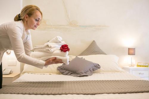 a woman is putting towels on a bed at Hotel Liberty Beach - Parking & Beach in Riccione