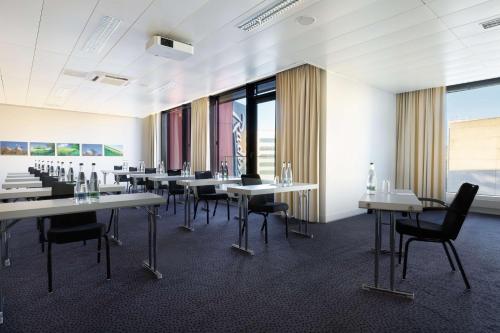a conference room with tables and chairs and windows at Radisson Blu Hotel Zurich Airport in Kloten