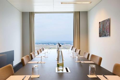 a conference room with a long table and chairs at Radisson Blu Hotel Zurich Airport in Kloten