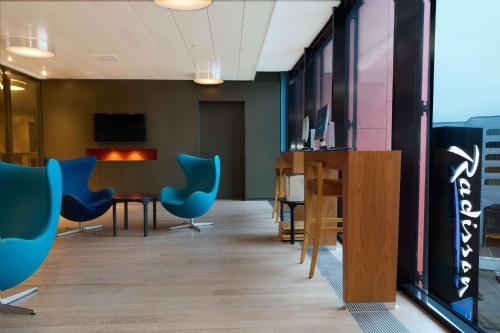 an office with blue chairs and a desk and a table at Radisson Blu Hotel Zurich Airport in Kloten